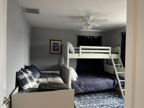 a bedroom with a bunk bed and a ceiling fan at Bayside Gem in Beach Haven Crest