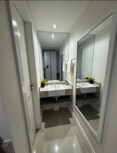 a bathroom with two sinks and a large mirror at True América apart-hotel in Campos dos Goytacazes