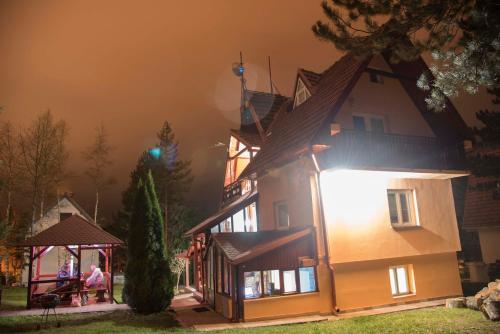 a large house with people standing outside of it at Apartment Velago in Zlatibor