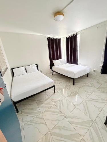 a room with two beds and a couch and a window at Adrian Hotel in San Francisco
