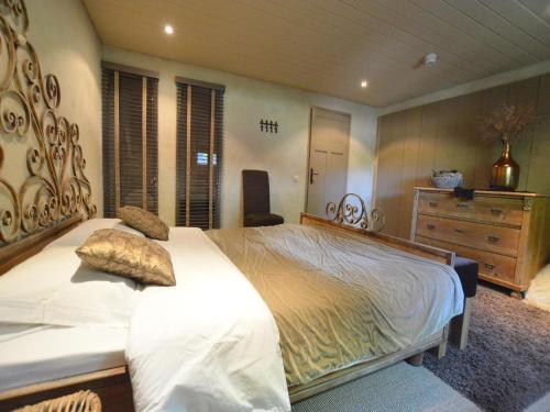 a bedroom with a large bed and a dresser at Alphen Retreat with Sauna in Alphen
