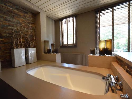 a large bath tub in a bathroom with windows at Alphen Retreat with Sauna in Alphen