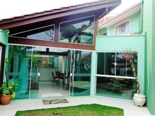 a house with large glass windows and a patio at Pousada Ares do Sul in Penha