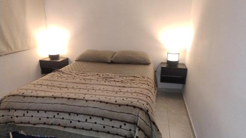 a bedroom with two lamps on two sides of a bed at Casa bella vista in Pocito