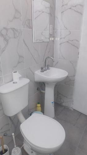 a white bathroom with a toilet and a sink at Casa bella vista in Pocito