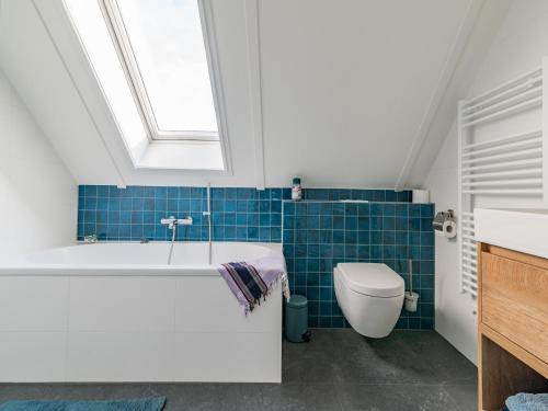 a bathroom with a tub and a toilet and a window at Fantastic villa located by a lake in Sint Nicolaasga
