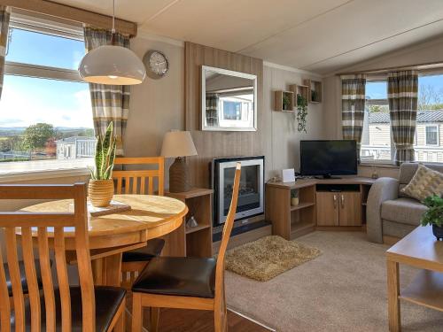 a living room with a dining table and a television at Hamilton Unit 145 in Eyemouth