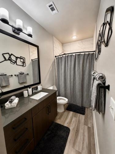 a bathroom with a sink and a toilet and a mirror at Excel Grand Stays in Frisco