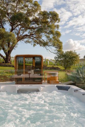 a hot tub in a yard with a tree at Miravino, winery stay with outdoor sauna and spa in McLaren Vale