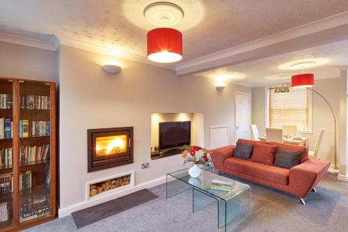 sala de estar con sofá y chimenea en Bright Moments Holiday Home, en Beverley