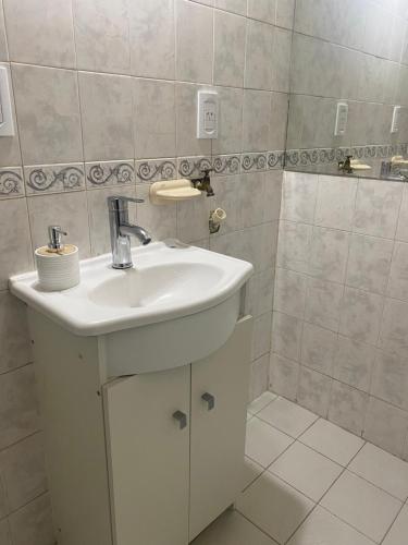 a bathroom with a white sink and a shower at Hogar in Río Gallegos