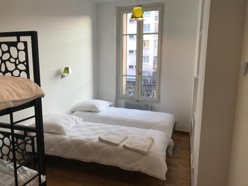 1 dormitorio con 2 camas y ventana en Appartement, Lyon, Villeurbanne, en Villeurbanne