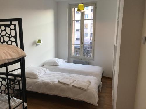 une chambre avec deux lits et une fenêtre dans l'établissement Appartement, Lyon, Villeurbanne, à Villeurbanne