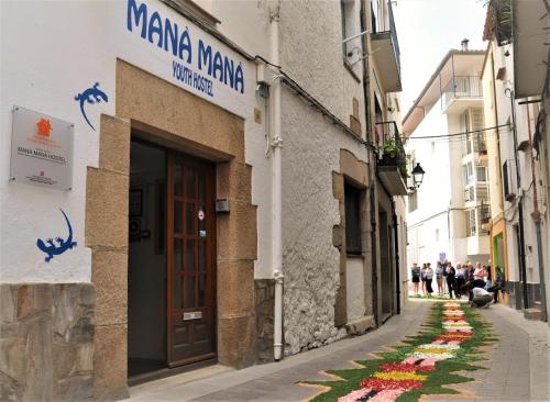 a street with flowers painted on the side of a building at Mana Mana Youth Hostel in Tossa de Mar