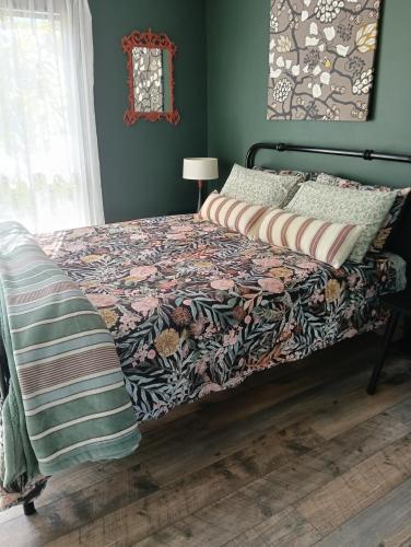 a bedroom with a bed with a floral comforter at Beautifully Elevated Treehouse Apartment in Buderim