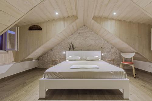 Holiday Home Stonehouse Popožo في بريموستين: غرفة نوم بسرير أبيض في العلية