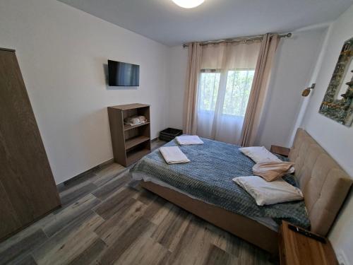 a small bedroom with a bed and a window at Apartamente VILLA 7 On The Beach in Eforie Nord