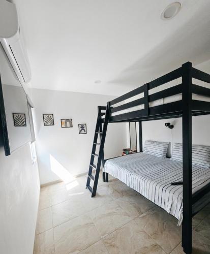 a bedroom with a bunk bed and a ladder at Casa Tulipanes Morelos, Alberca Climatizada, Jacuzzi y Roof in Morelos