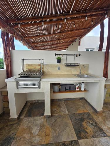 an outdoor kitchen with a grill and a sink at Casa Tulipanes Morelos, Alberca Climatizada, Jacuzzi y Roof in Morelos