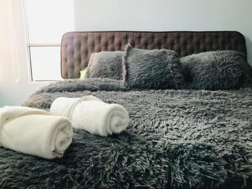 a bed with towels and pillows on it at GV Aparta Suites Apto Familiar Amplio y Luminoso in Chía