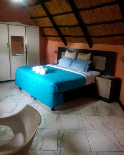 a bedroom with a large blue bed in a room at Niasha Gardens in Chinhoyi