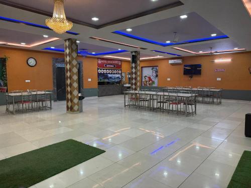 a banquet hall with tables and chairs and a tv at Amar mahal hotel and restaurant in Khātu