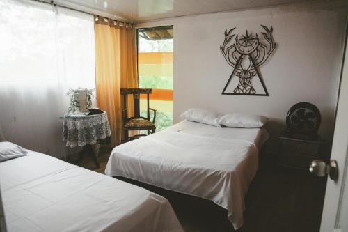 a bedroom with two beds and a picture on the wall at Tierra Mágica eje cafetero in Manizales