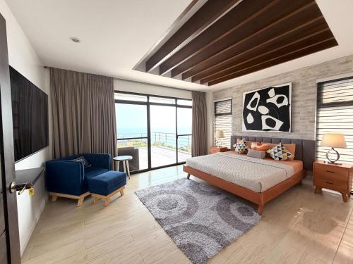 a bedroom with a bed and a blue chair at Villa Amihan in Puerto Galera