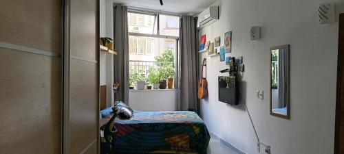 a hallway with a chair in a room with a window at Angel's House Flamengo RJ in Rio de Janeiro