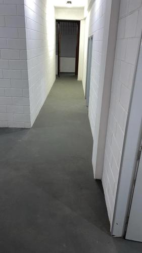 an empty hallway with white brick walls and a door at Pousada Fortaleza SP 8 in São Paulo