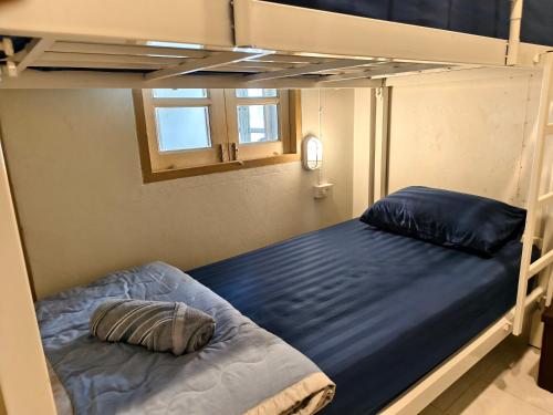 a bunk bed in a room with a bed gmaxwell gmaxwell gmaxwell gmaxwell gmaxwell at Happy Homey Hostel in Suratthani