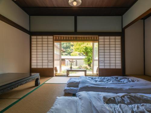a bedroom with two beds and a large window at 汐見屋 in Tanabe