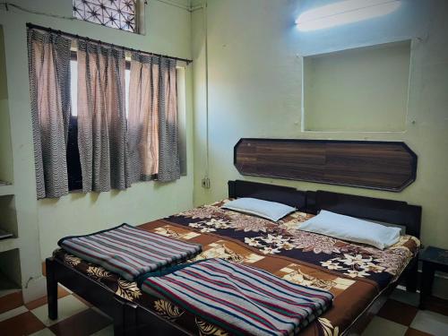 a bedroom with a bed with two pillows on it at Gaurav Guest House in Mathura