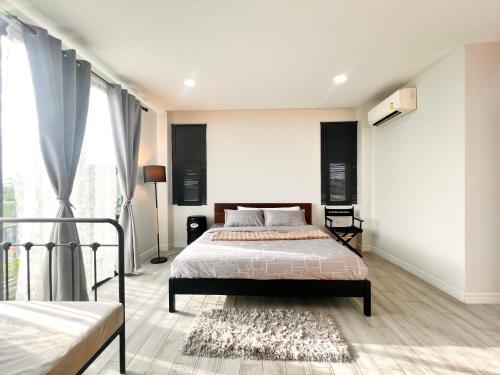 a bedroom with a bed and a large window at LECAR Home Shelby in Ban Nong Khang