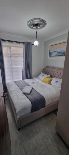 a bedroom with a large bed in front of a window at Dolphin Homestays in Nairobi