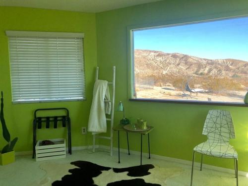 a green room with a window and a table and chairs at Casa Soza in White Water