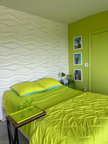 a bedroom with a yellow bed and a table with glasses on it at Casa Soza in White Water