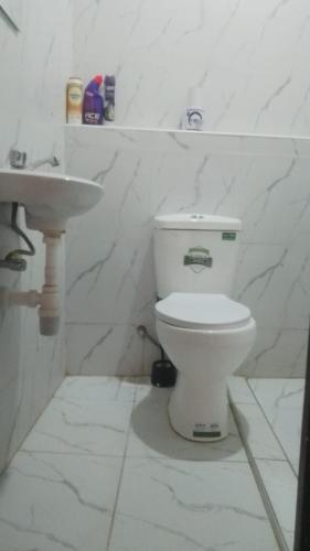 a white bathroom with a toilet and a sink at Dolphin Homestays in Nairobi