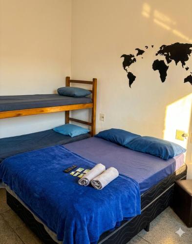 two bunk beds in a room with a map on the wall at Pousada Ocean Próx Sesc Bertioga - Beira Mar in Bertioga