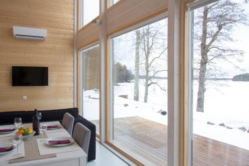 a living room with a large window and a table and chairs at Ammatour Villas in Uro