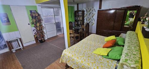 a bedroom with a bed with green and orange pillows at Casa Lulú in Mexico City