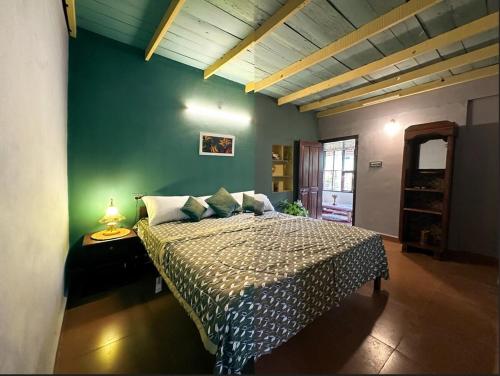 a bedroom with a bed and a green wall at Mass Bungalow in Tindummal