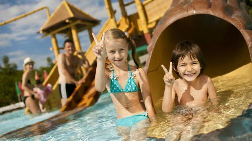 two children in the water on a slide at a water park at Čebelarjeva hiška 1 - Terme Olimia - Podčetrtek in Podčetrtek