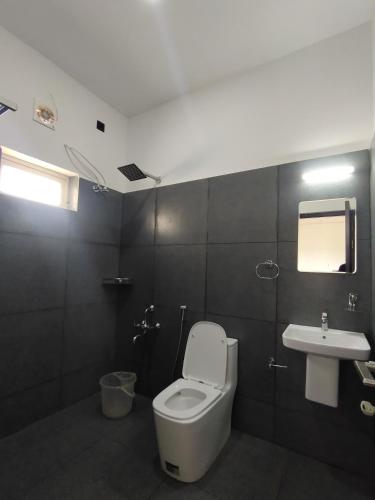 a bathroom with a toilet and a sink at Adithya resort vagamon in Vagamon