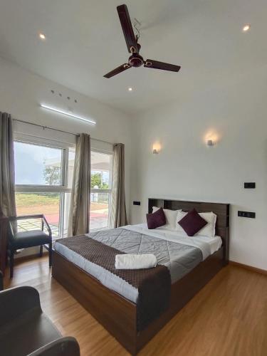 a bedroom with a large bed with a ceiling fan at Adithya resort vagamon in Vagamon