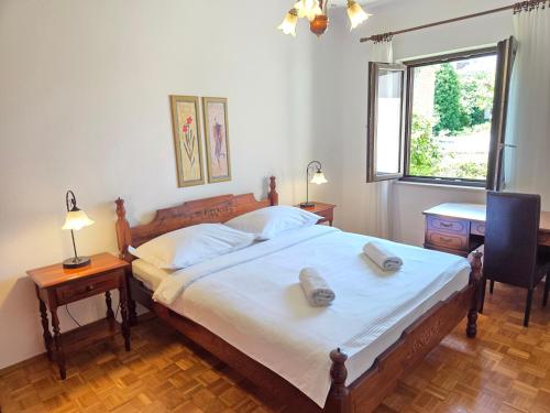 a bedroom with a bed and a desk and a window at Apartments Romana in Postira