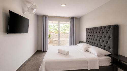 a bedroom with a large bed with a black headboard at Apartamentos cerca al centro de Cali in Cali