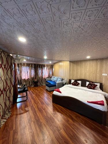 a bedroom with a large bed and a couch at The Nigeen Lodge in Srinagar
