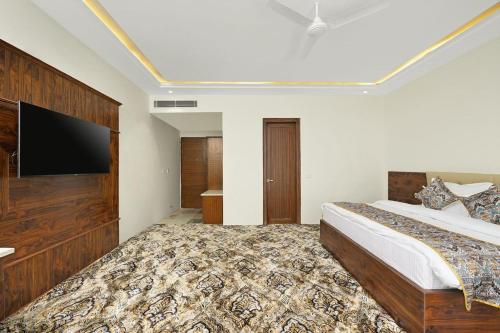 a bedroom with a large bed and a flat screen tv at Hotel paras in Dera Bassi