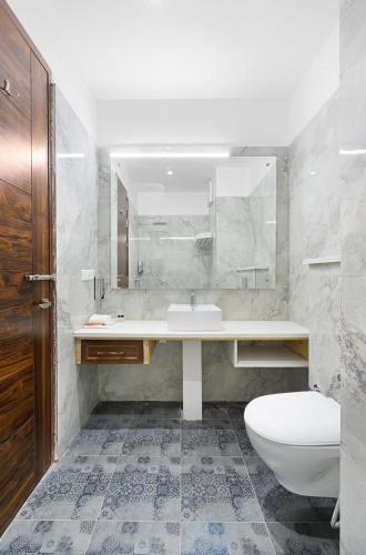 a bathroom with a sink and a toilet and a mirror at Hotel paras in Dera Bassi